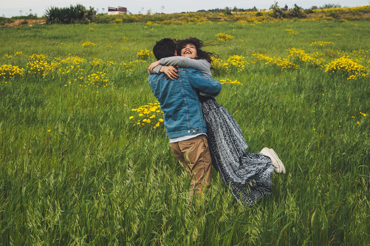 Novio y novia jugando abrazados en el campo